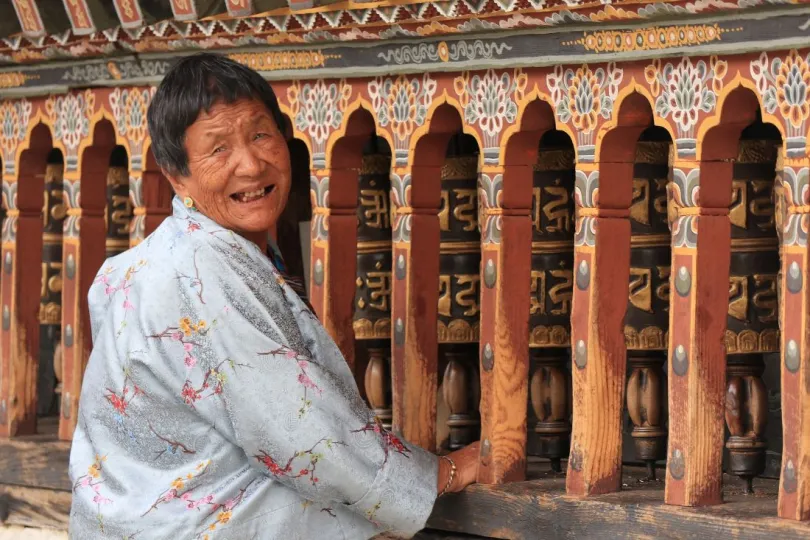 Bhutan vrouw bij gebedsrollen