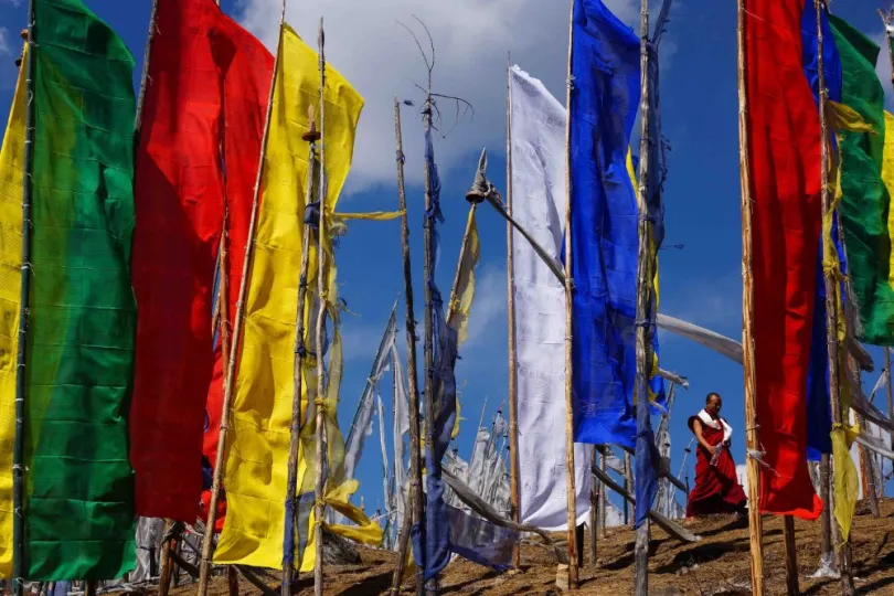 Bhutan monnik bij gebedsvlaggen