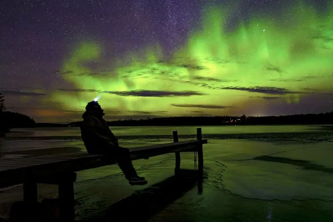 Persoon kijkt naar het noorderlicht in Finland