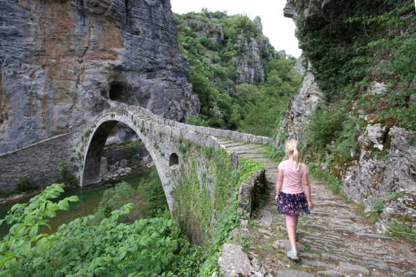 Meisje loopt op oude brug in Griekenland