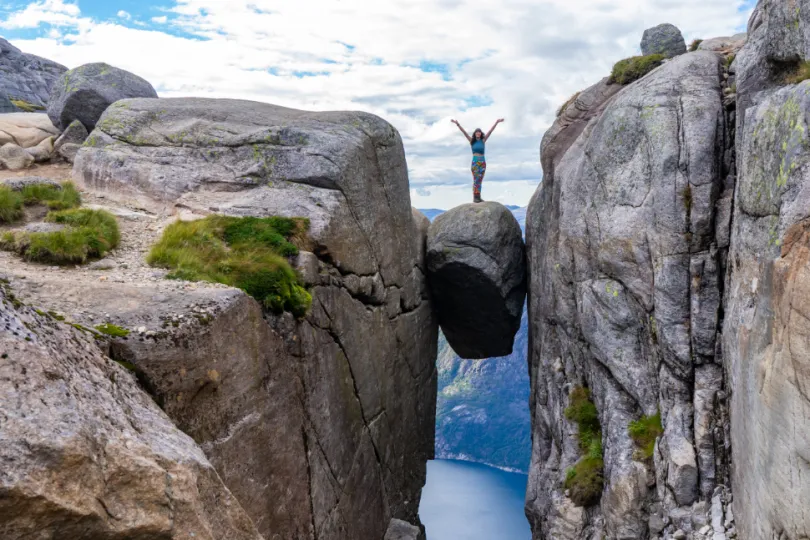 Vrouw op rotsblokken in Noorwegen