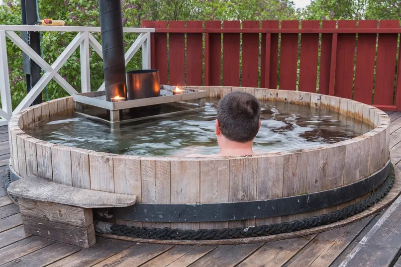 Bijzonder overnachten Zweden - reiziger in een hot tub.