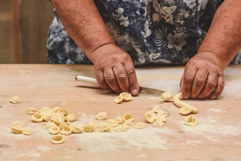 Vrouw die orecchiette maakt in Puglia.