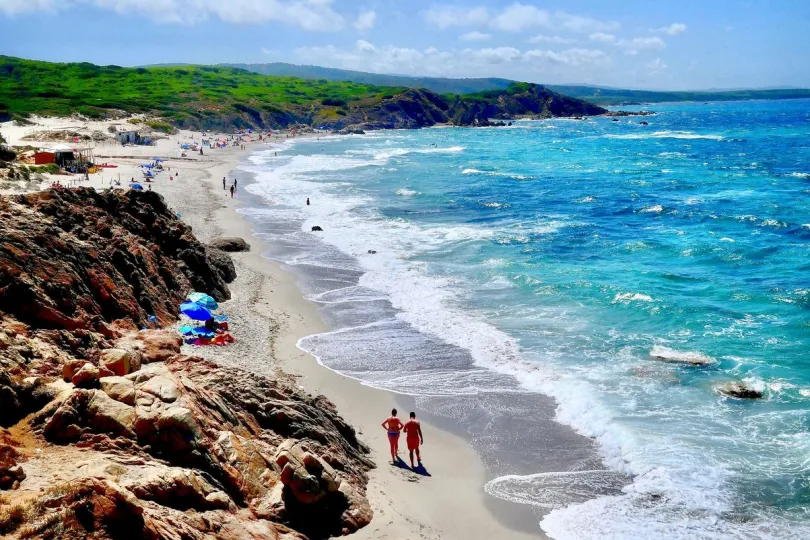 Italië reizen - reizigers op het strand strand op Sardinië.