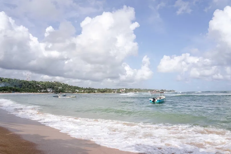 Unawatuna strand Sri Lanka met een bootje in de zee.