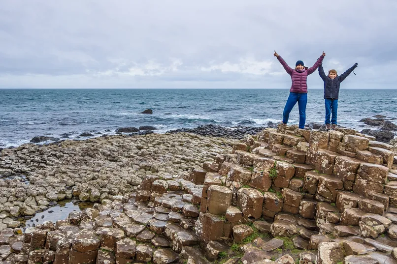 Twee reizigers bij de duizend basalt pilaren van Giants Causeway.