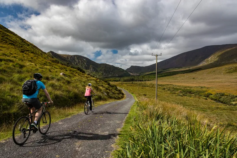Twee reizigers fietsen in het landschap van Ierland.