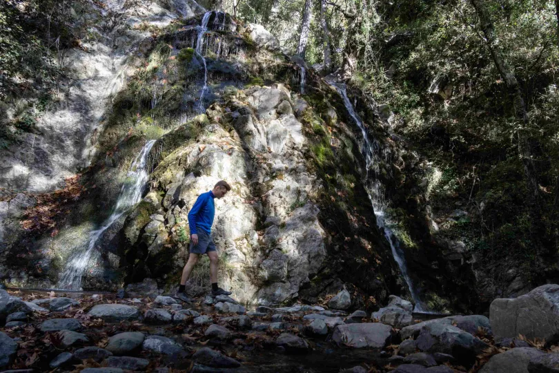Man lopend langs een waterval.