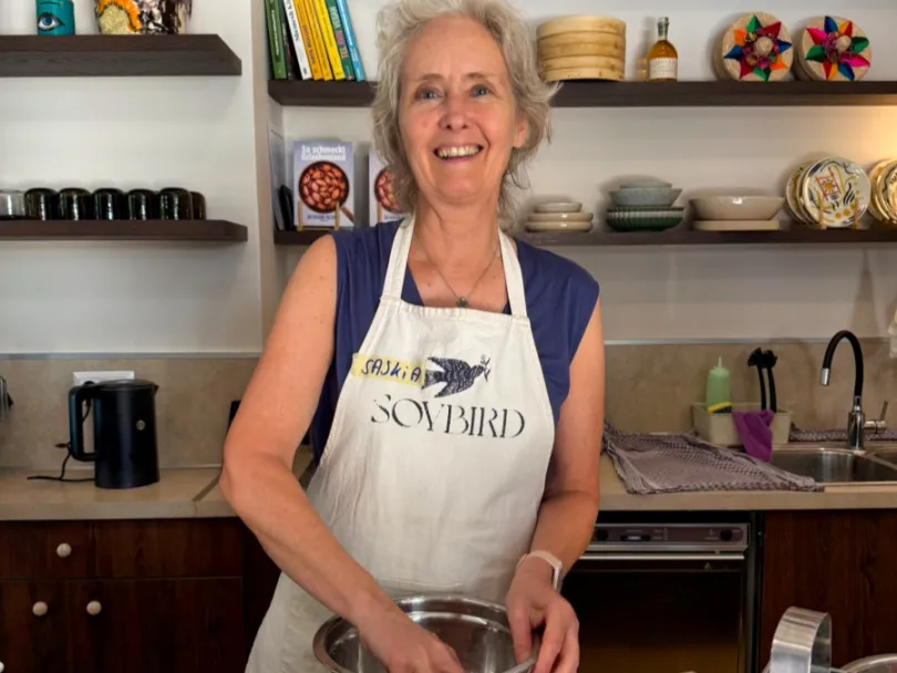 Een vrouw roert met haar hand in een kom tijdens een kookworkshop in Griekenland.