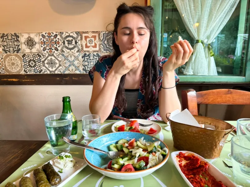 Vrouw eet in Grieks restaurant.