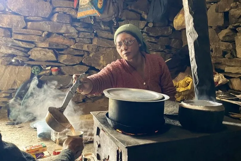Een herder die een warm drankje schenkt in Thangso, Ladakh.