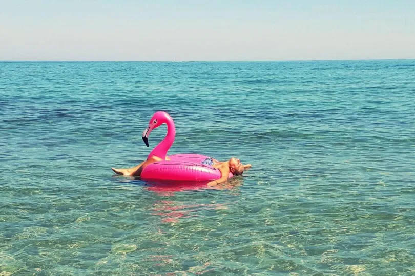 Opblaasbare flamingo in de zee met mevrouw