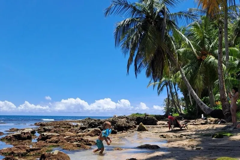 Kind loopt over het strand in costa rica
