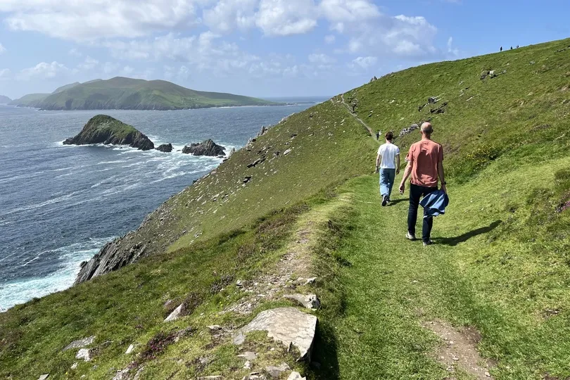 Reizigers belopen pad van Dingle Peninsula