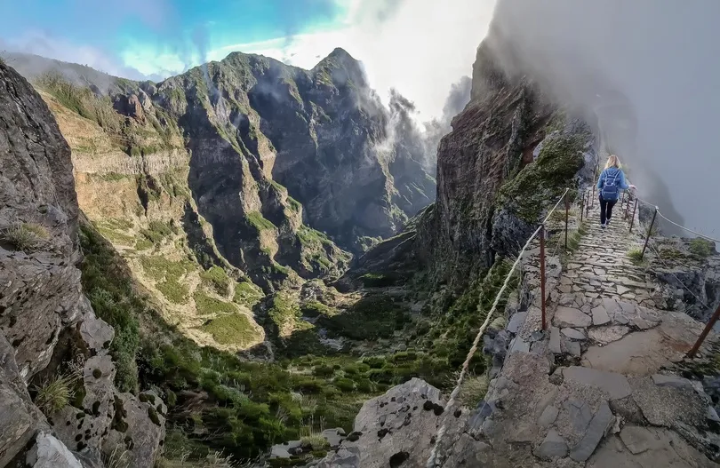 Iemand bewandelt de hike Pico de Arieiro en er is een uitzicht te zien van een bergkloof.