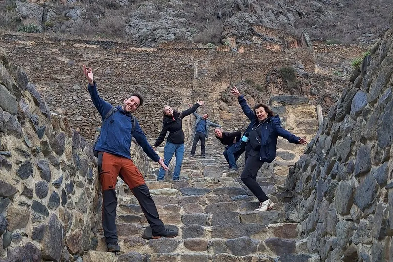 Mensen poseren enthousiast in Ollantaytambo, Peru.