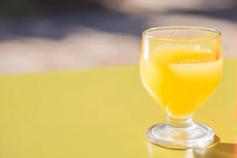 Een geel alcoholisch drankje uit Madeira in een klein wijn glaasje.