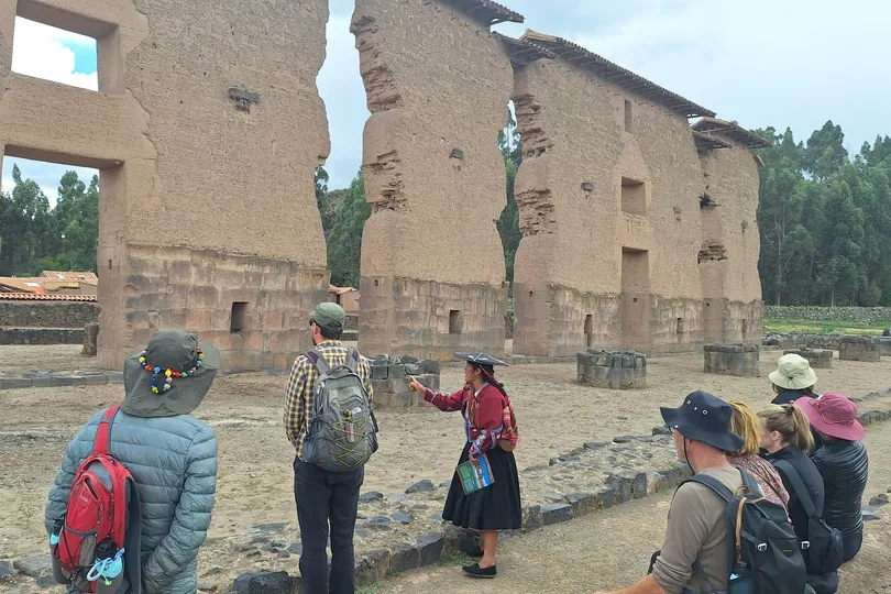 Een groep staat bij een bezienswaardigheid in Raqchi, Peru.