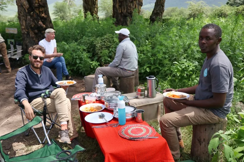Twee mannen genieten van hun lunchpauze tijdens een safari in Tanzania.