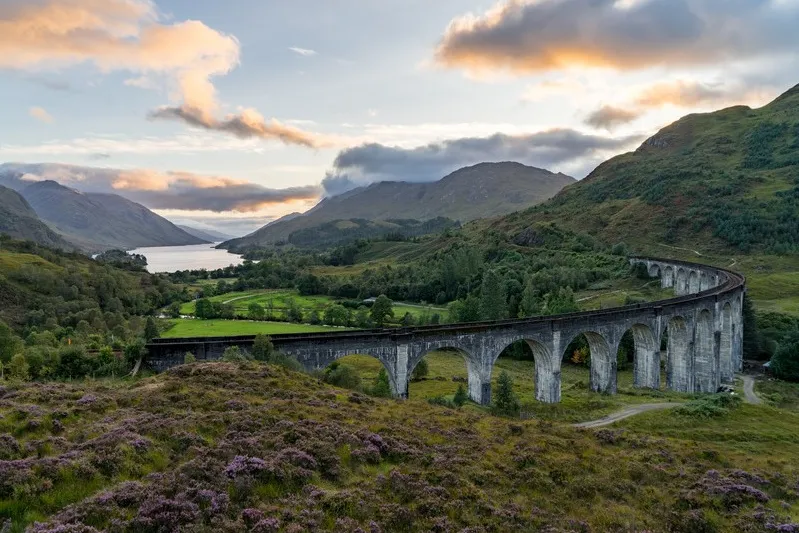Glenfinnan Railway Viaduct in het landschap met bergen op de achtergrond.