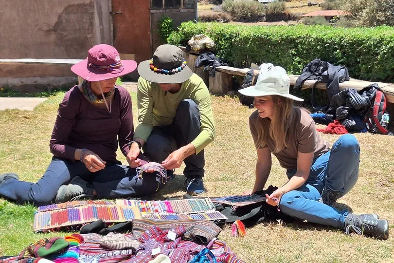 Drie mensen leren weven in Peru.