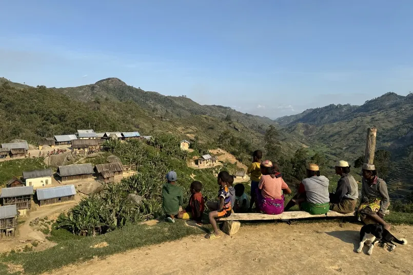 Locals op een bankje met uitzicht op gebergte in Madagaskar.