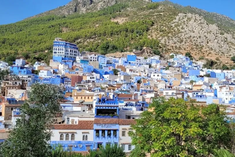 Heel veel blauw gekleurde huizen gelegen aan een berg. 