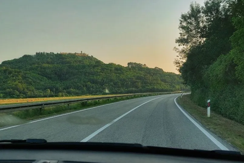 Een autoweg tussen wat groene bergen. 