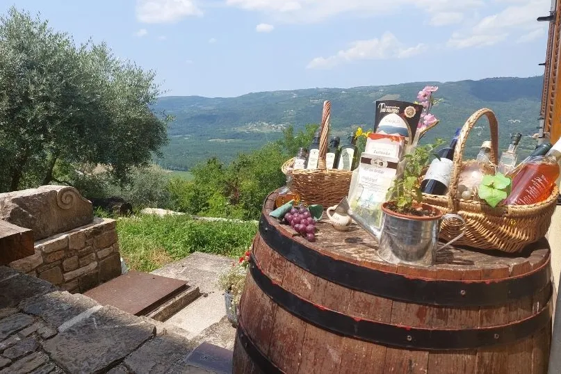 Een barrel met diverse olijfolies, wijnen, druiven.