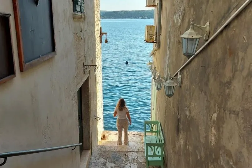 Reisexpert Melissa kijkt uit op de kust staande in een small straatje van Rovinj.