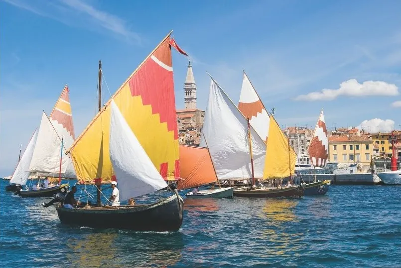 Kleurijke zeilboten aan de kust in prachtig blauw water. 