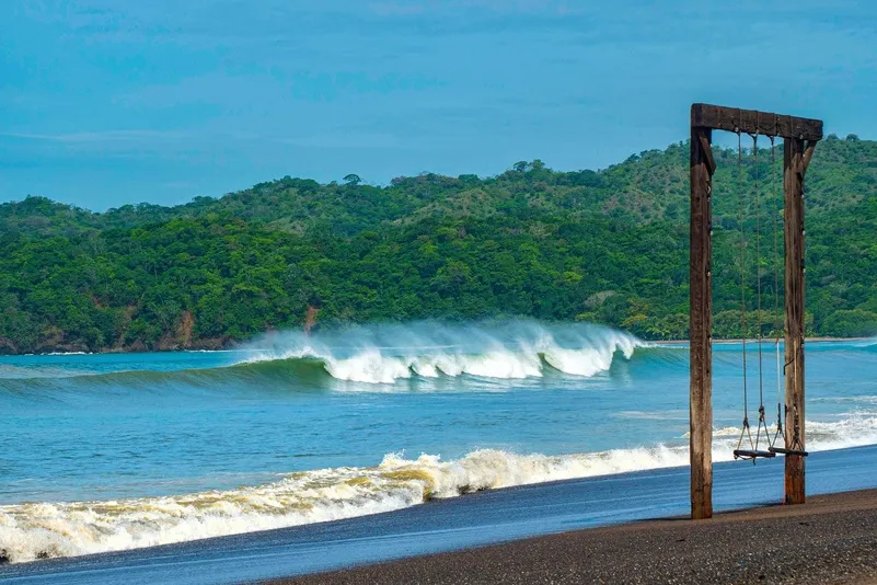 Panama - Playa Venao met schommel en bergen op de achtergrond.