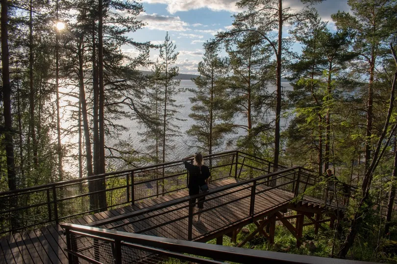 Vrouw kijkt uit op het meer in Finland.