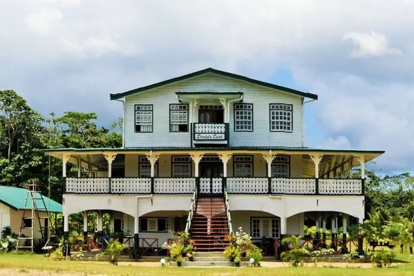 Lindes Lust in Suriname, koloniaal houten huis met veranda in een groene omgeving.