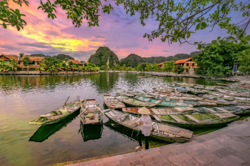 Rivier in Hoi An bij zonsondergang, met meerdere kleine bootjes.
