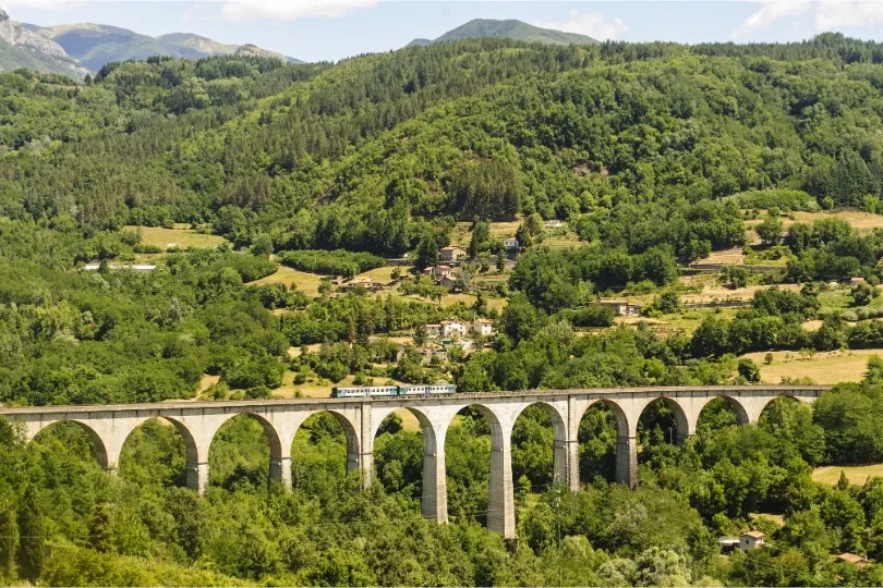 Italië, Toscane met de trein over een brug door natuur.