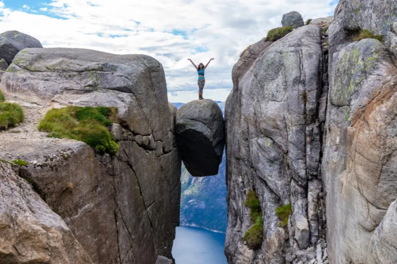 Vrouw op rotsblokken in Noorwegen.