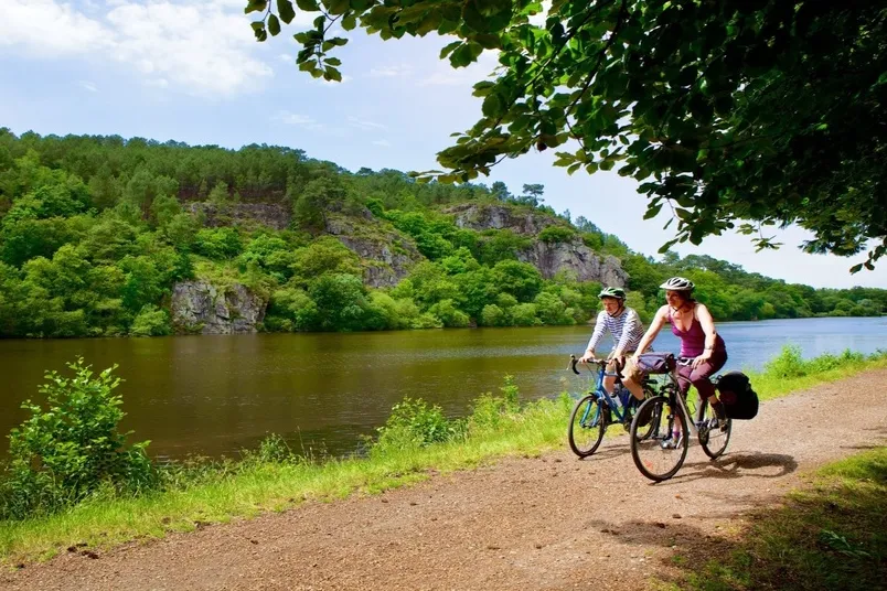 Redenen fietsvakantie Bretagne - twee reizigers aan het fietsen langs het water.