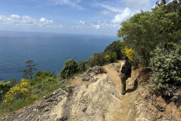 Vrouw wandelt langs de kust in Toscane.