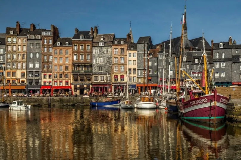 Een pittoresk haventje in Honfleur, Normandië, met gekleurde zeilboten in het water