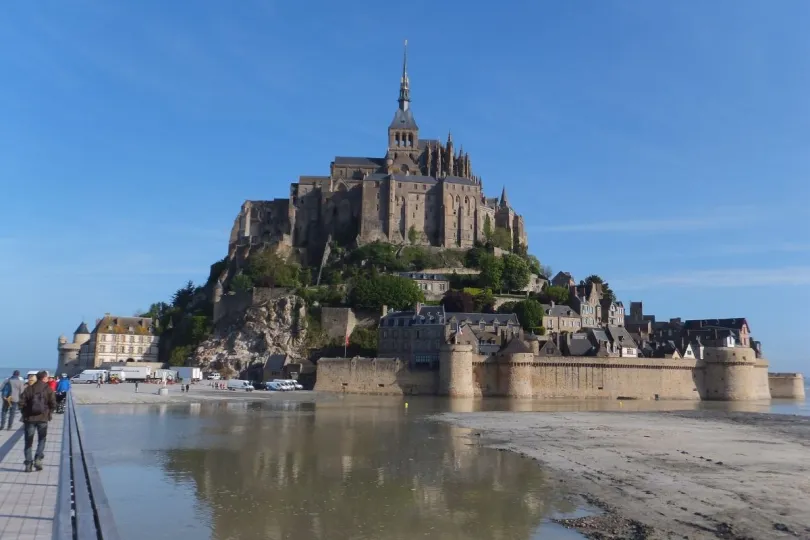 Mont Saint-Michel met mensen die over de brug naar de berg lopen