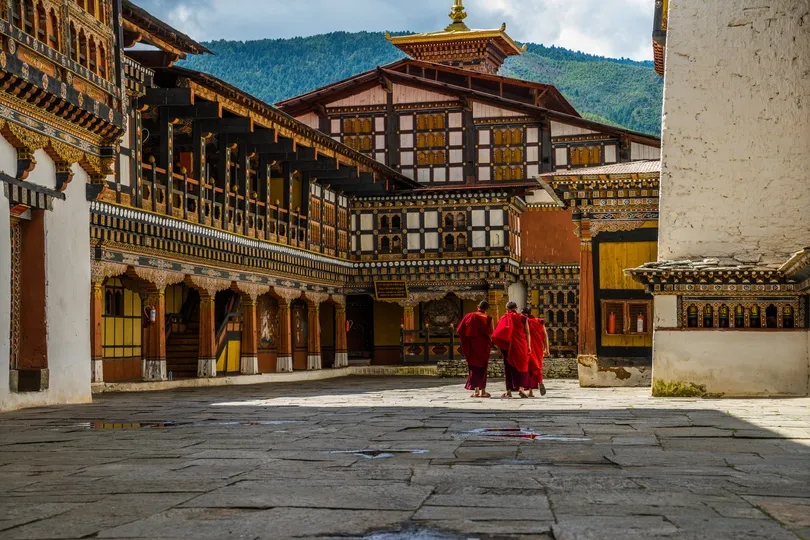 Drie monniken wandelen in Bhutan.