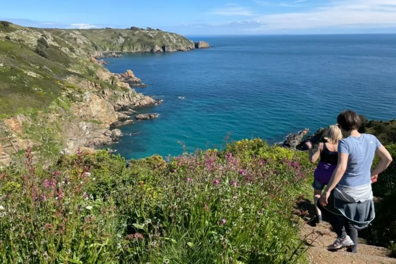 Twee vrouwen wandelen langs de kust op Guernsey, één van de Kanaaleilanden.