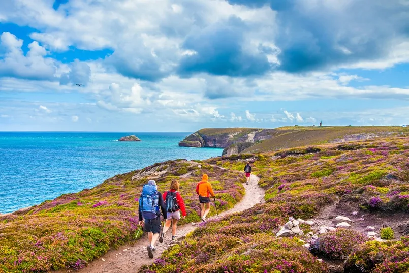 Reizigers wandelen in Bretagne over de Roze Granietkust met de zee.