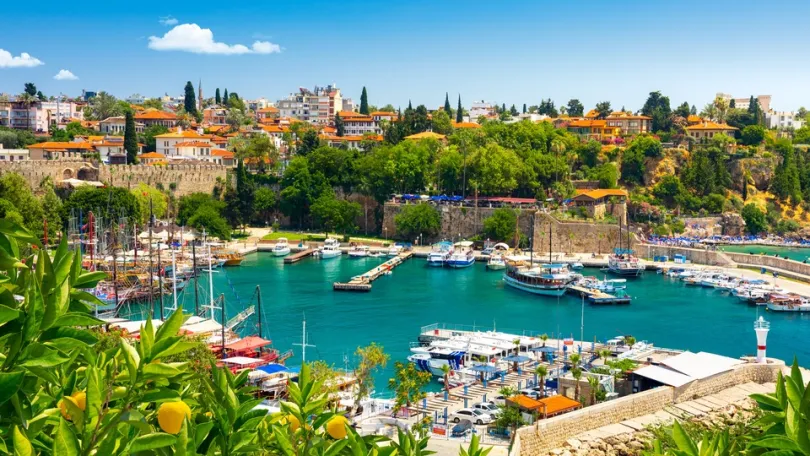 De haven van Antalya met jachten en de oude binnenstad op de achtergrond.