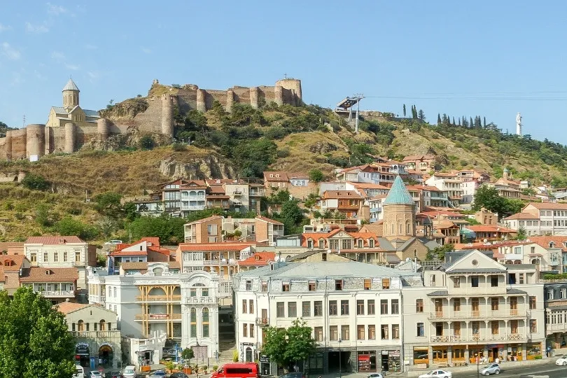 Tblisi historische stad met een fort op een heuvel en kleurrijke gebouwen.