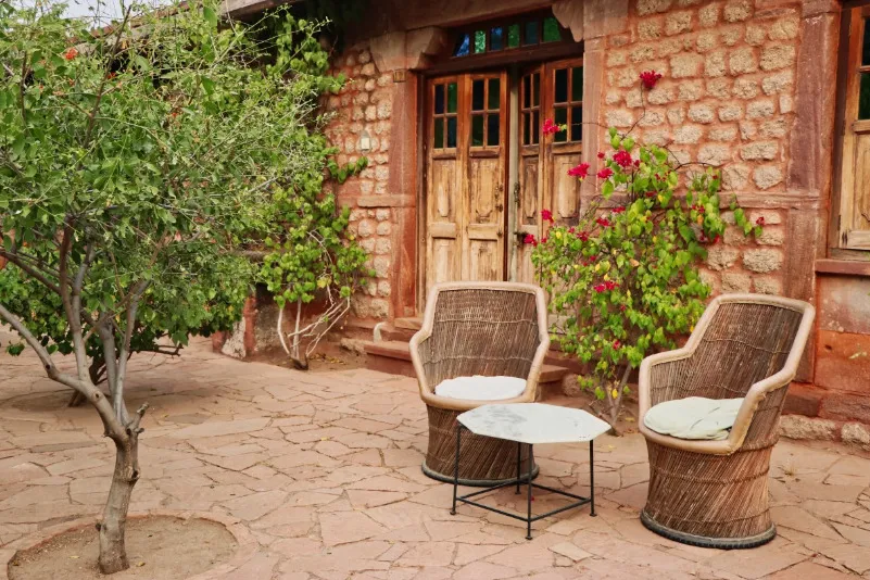 India Chandalao Garh homestay met twee stoelen en een boompje - LIMITED RIGHTS Daisy.