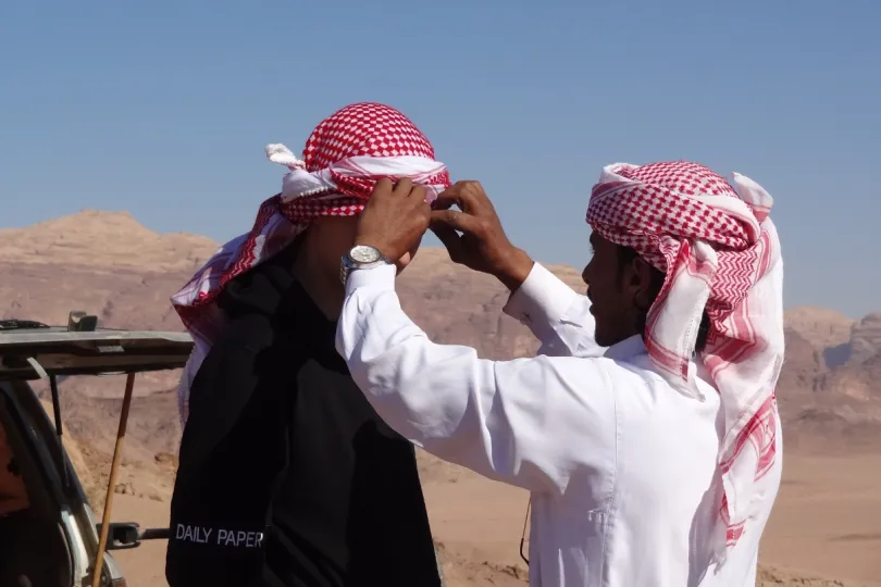 Gezinsvakantie Jordanië - een reiziger en local tulbanden aan het opdoen.