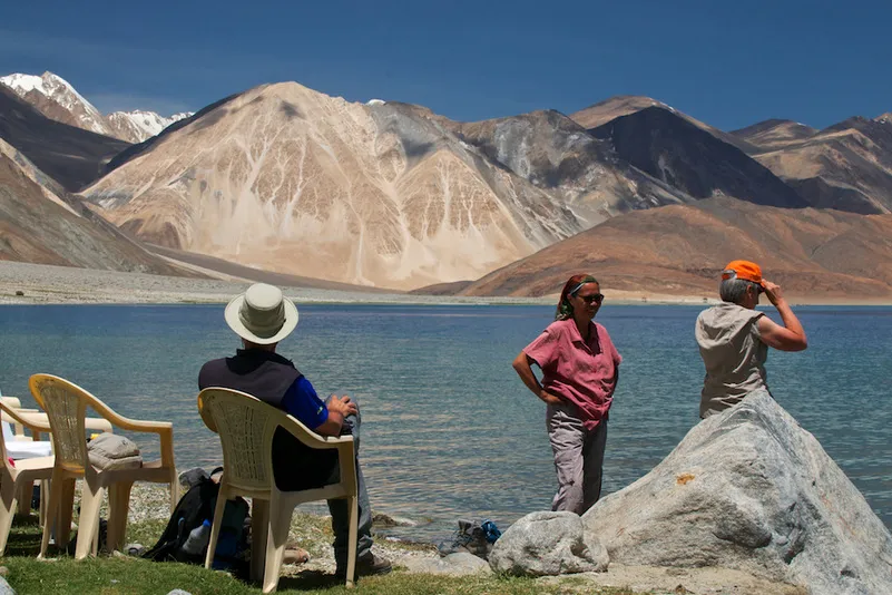 Trekking in Ladakh - mensen bij het Pangong meer op stoelen en staand.