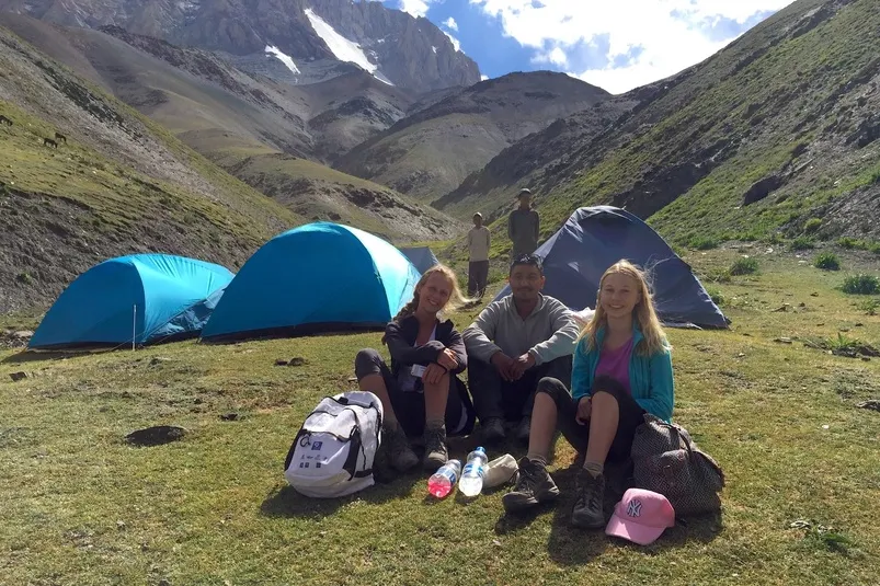 Ladakh trekking - reizigers die voor tenten zitten in de bergen.